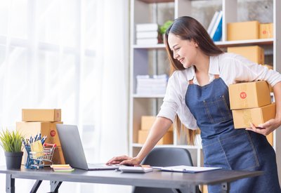 concept for delivery - a woman with cartoon boxes in an office