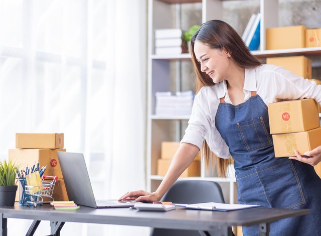 concept for delivery - a woman with cartoon boxes in an office